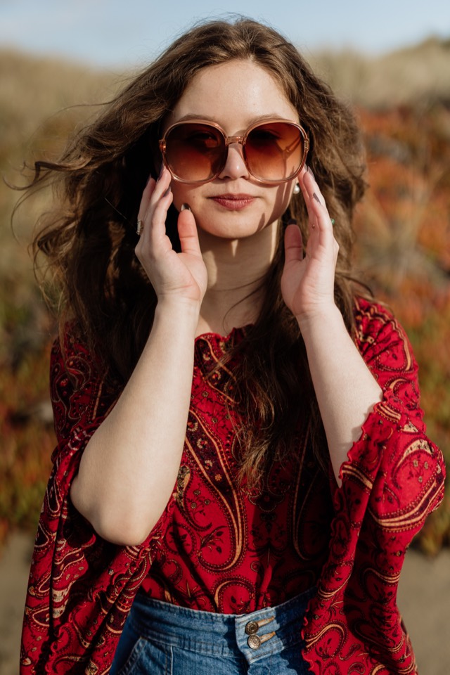 Senior in a red patterned top, windswept in golden grass