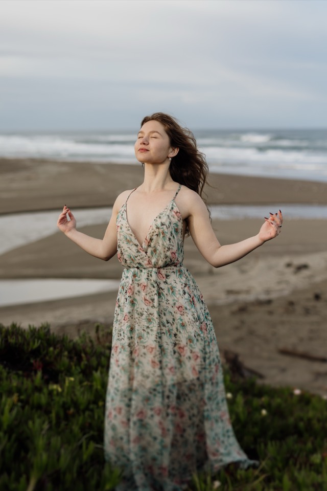 Senior walking on the dunes, dress moving in the wind